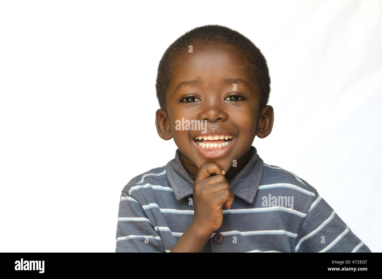 Portrait von afrikanischen schwarzen Junge Kind lächelnd mit toothy Lächeln isoliert auf weißem Stockfoto