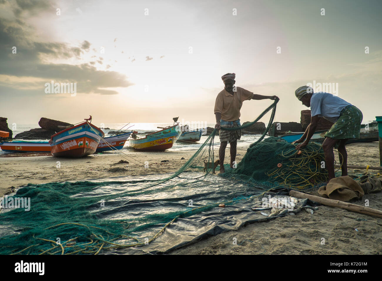 Zwei Fischer, die ihre Netze an den Strand auf Tranquebar in Tamil Nadu in Südindien Stockfoto