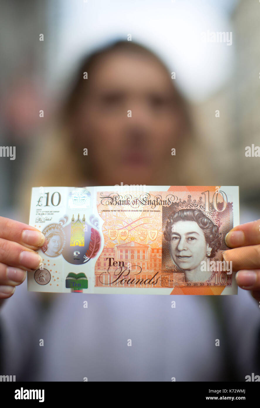 Eine Frau hält eine neue zehn Pfund Hinweis mit Jane Austen, in Birmingham High Street. Stockfoto