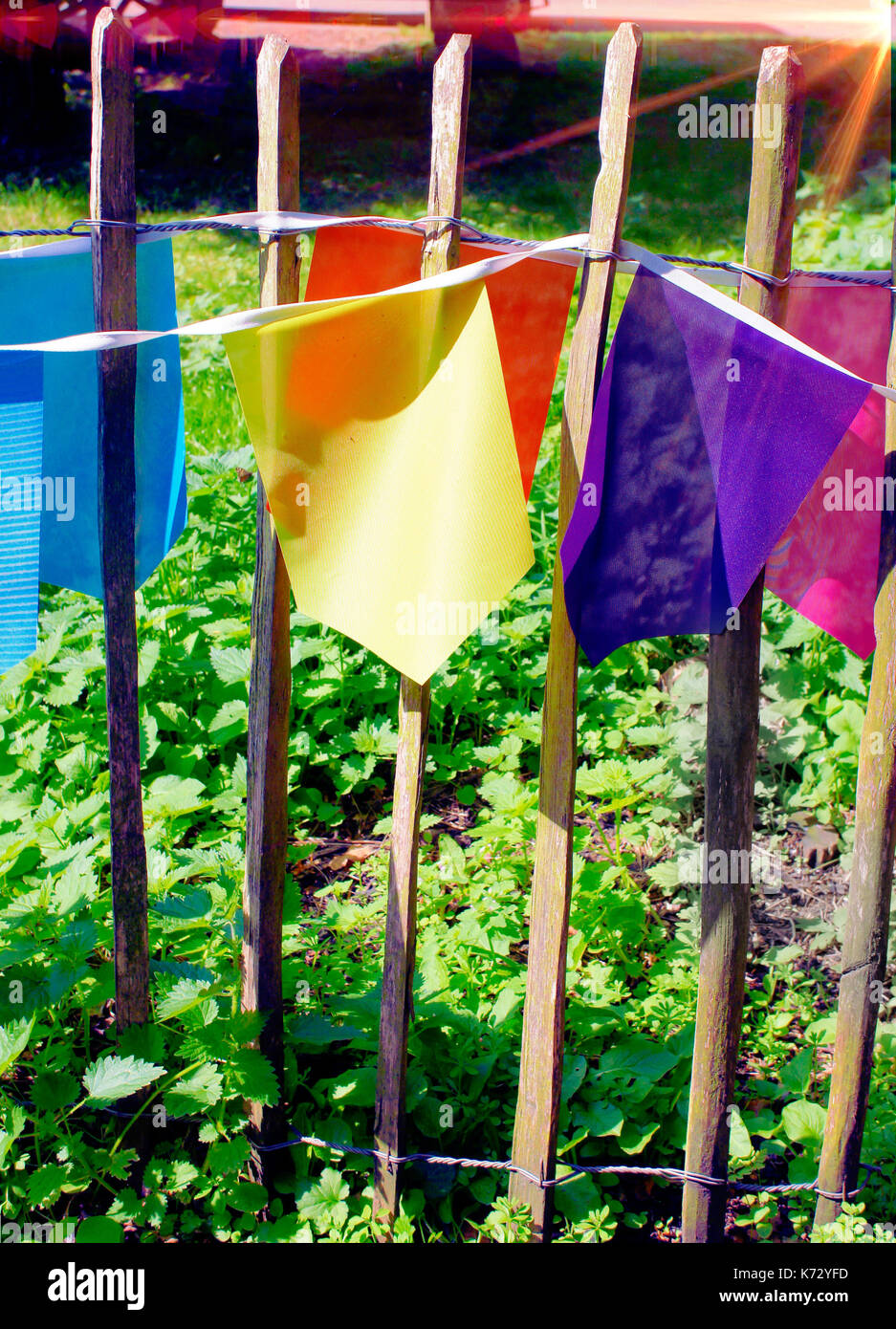 Mehrfarbige bunting Flag in einem Holzzaun mit Licht Aufflackern von der Sonne Stockfoto