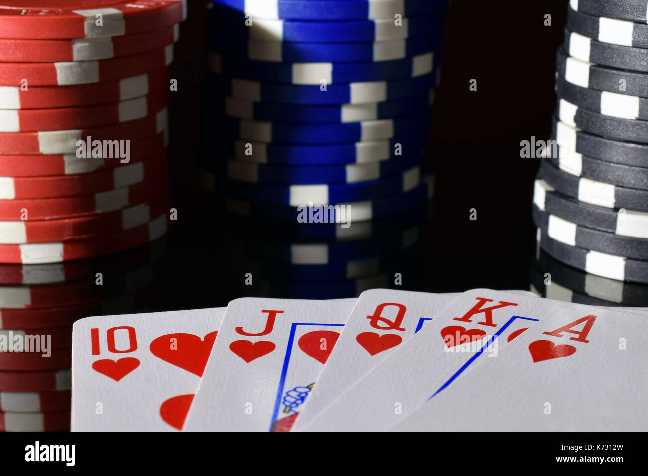 Poker Hand Royal Flush auf Schwarz reflektierende Board. Poker chips für den Hintergrund. Stockfoto