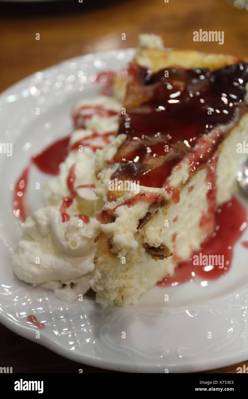 Scheibe der New Yorker Stil, Käsekuchen mit Himbeeren und Sahne Sauce auf einer Platte Stockfoto