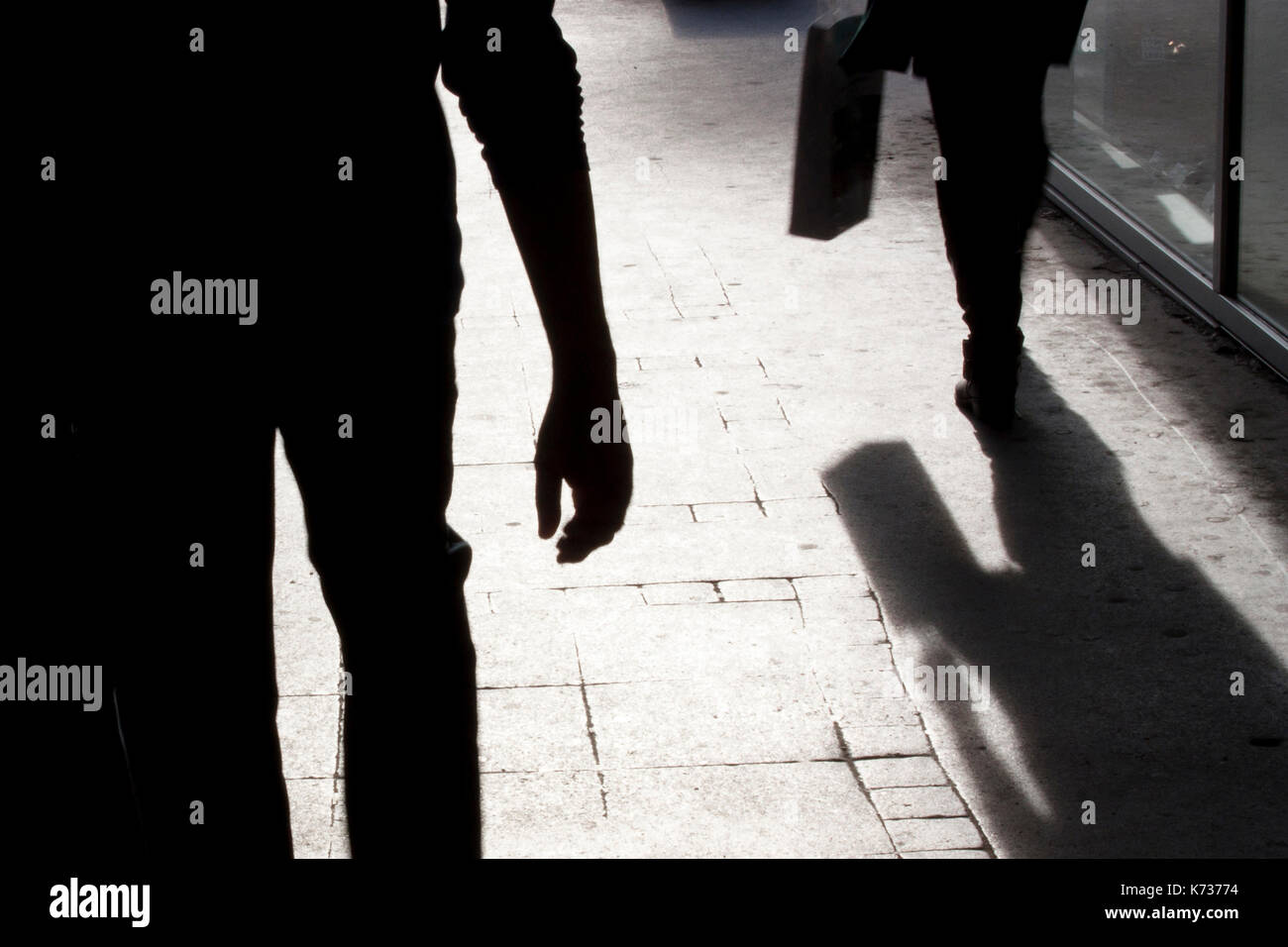 Unscharfe Silhouette und Schatten einer Frau, die eine Tasche und ein Mann ihr nach und in der Stadt Straße in der Nacht Stockfoto