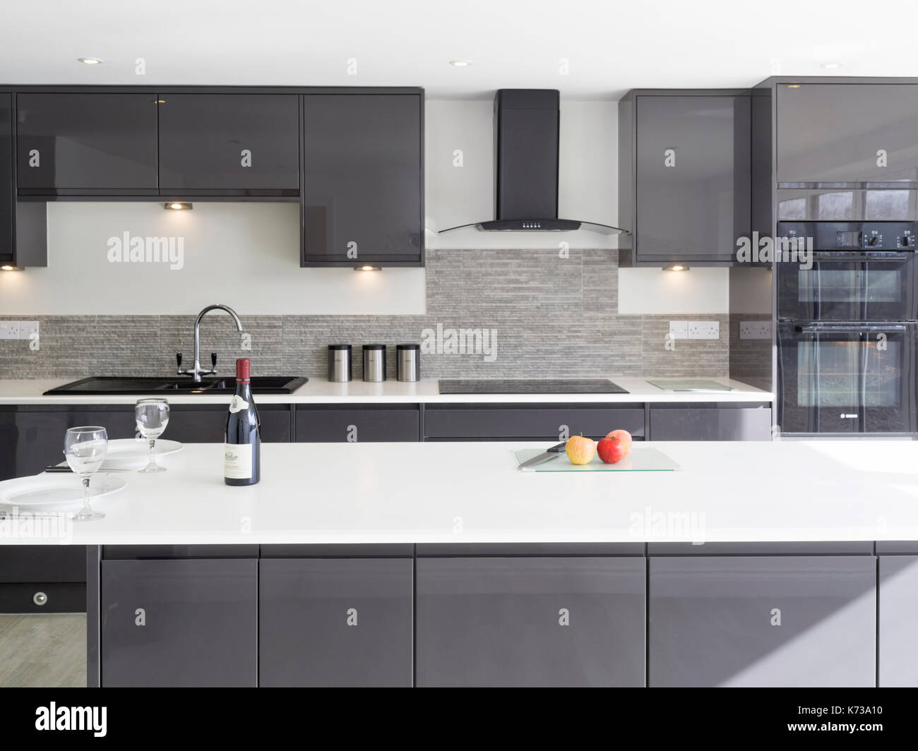 Eine moderne, minimal, monochrome heimische Küche mit Insel und solide Arbeitsplatten in einem modernen uk Home Stockfoto