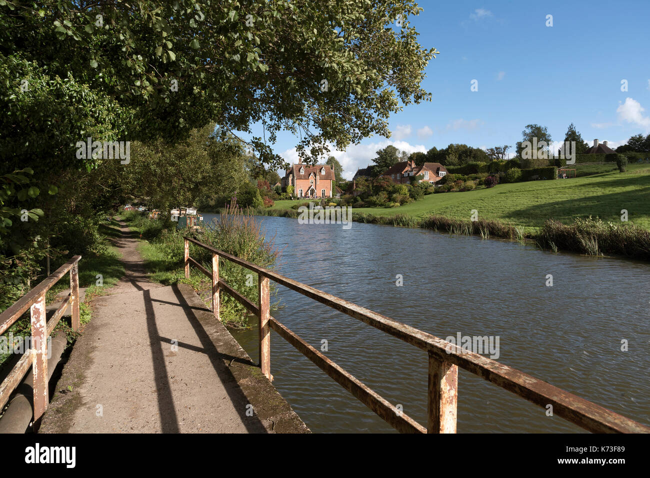 Kennet and Avon Canal in Kintbury Berkshire England UK. September 2017. Steg und Leinpfad entlang des Kanals mit großen Grundstück im Hintergrund Stockfoto