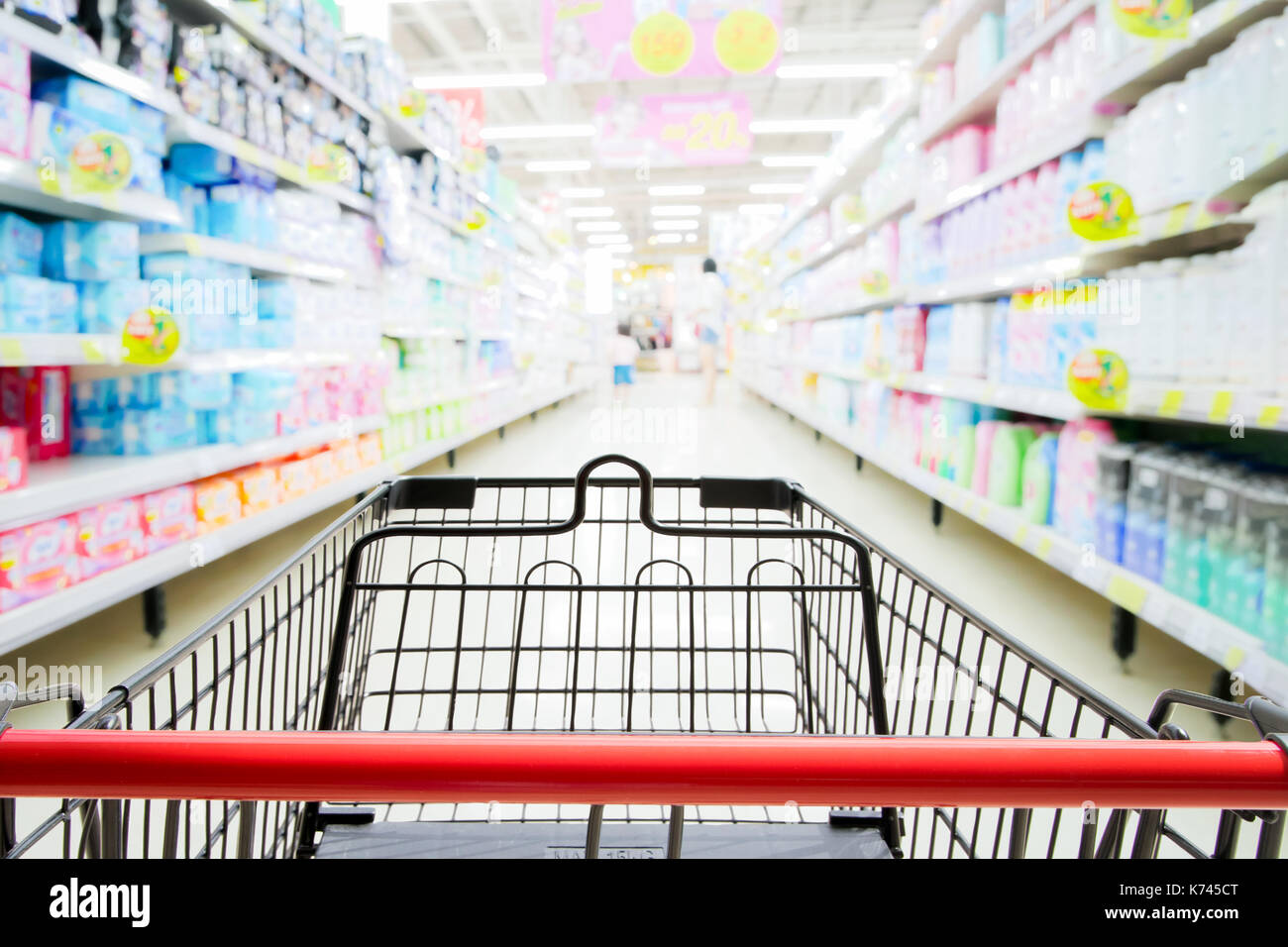 Einkaufswagen im Supermarkt mit blured Supermarkt gang und Regale Hintergrund Stockfoto