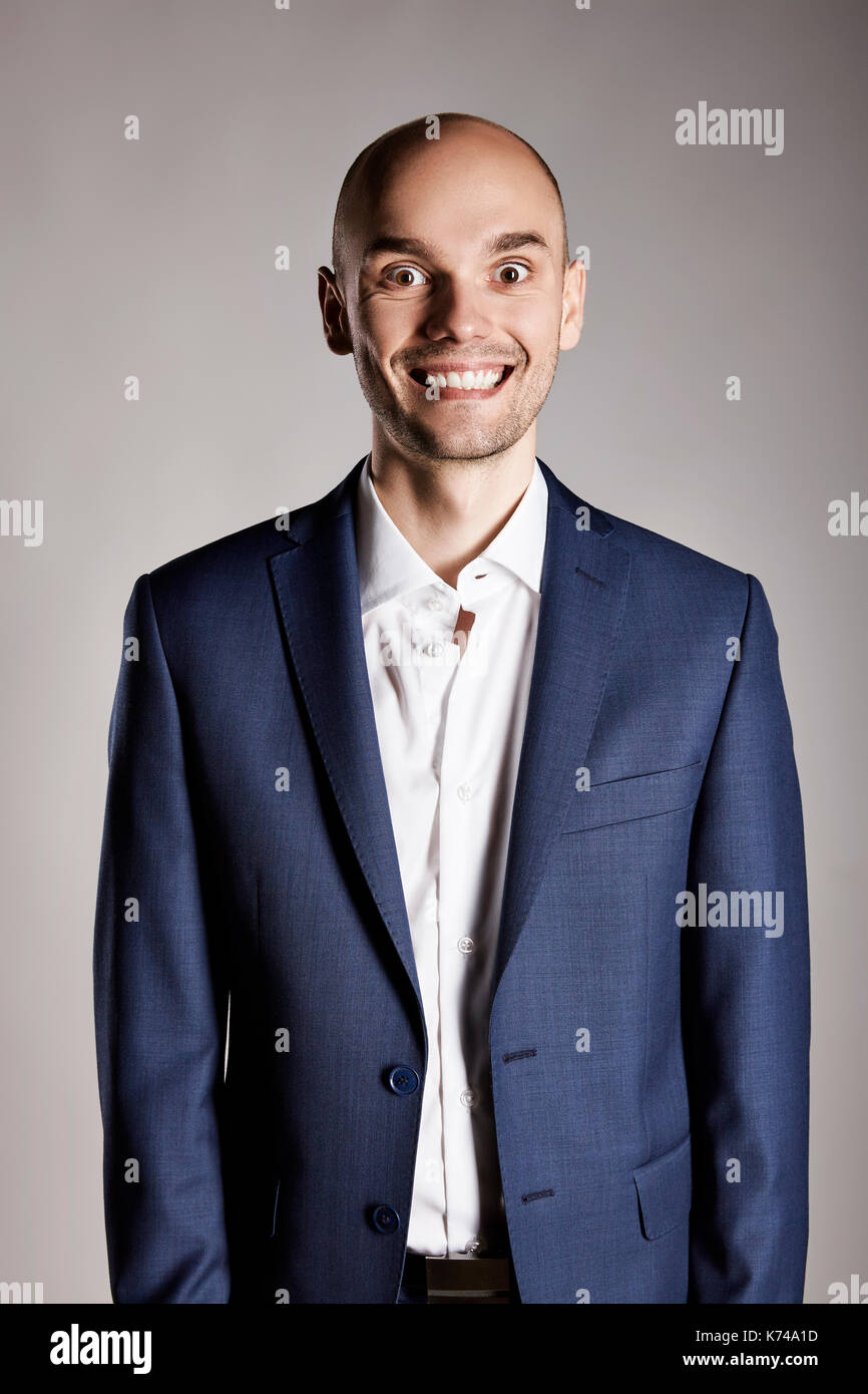 Junger Mann in Anzug ist ein lustiges Gesicht. Stockfoto