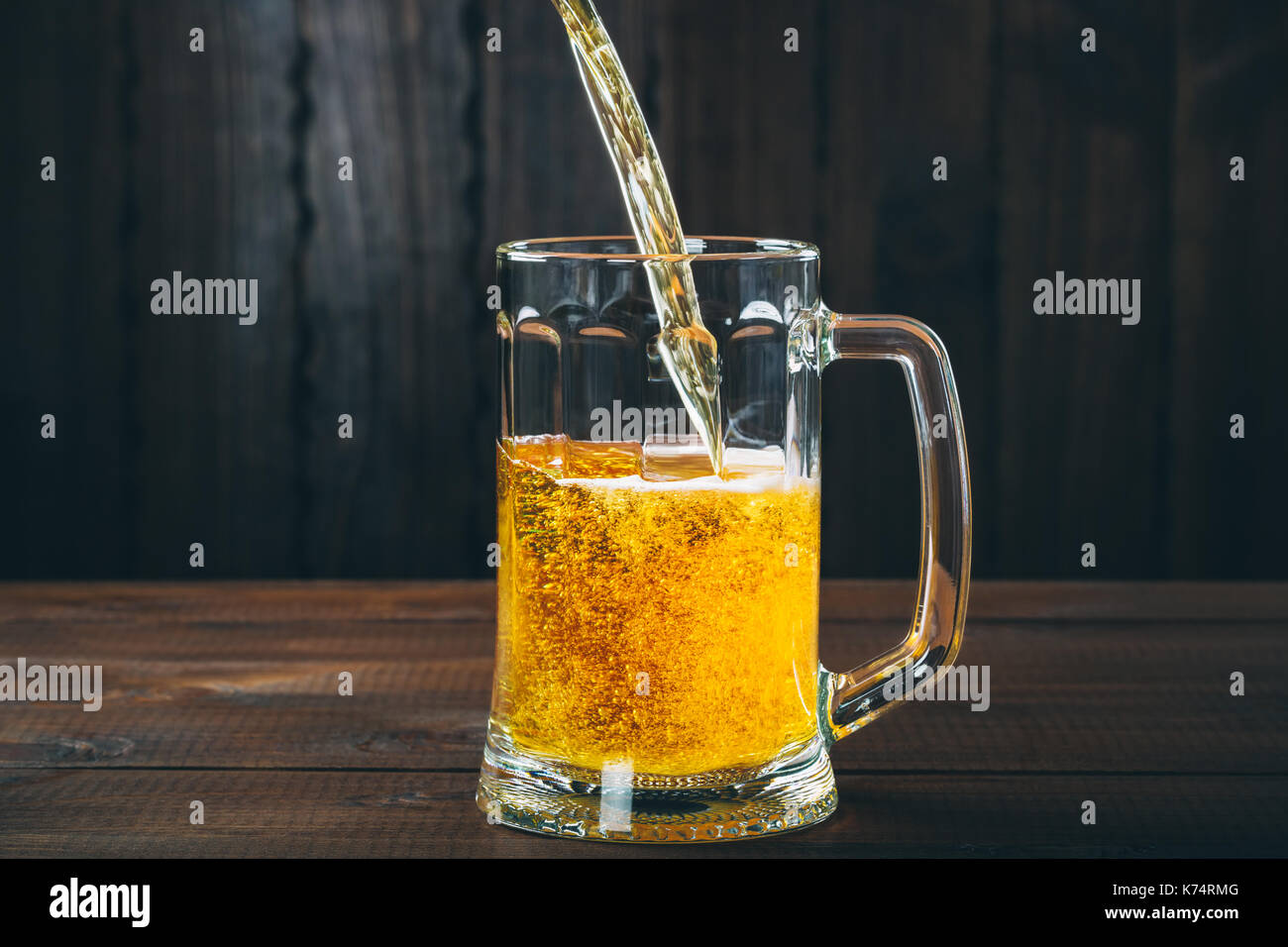 Handwerk Bier ergossen sich in einem Pint Glas auf dem Holz- Hintergrund. Schönen Hintergrund des Oktoberfestes Stockfoto