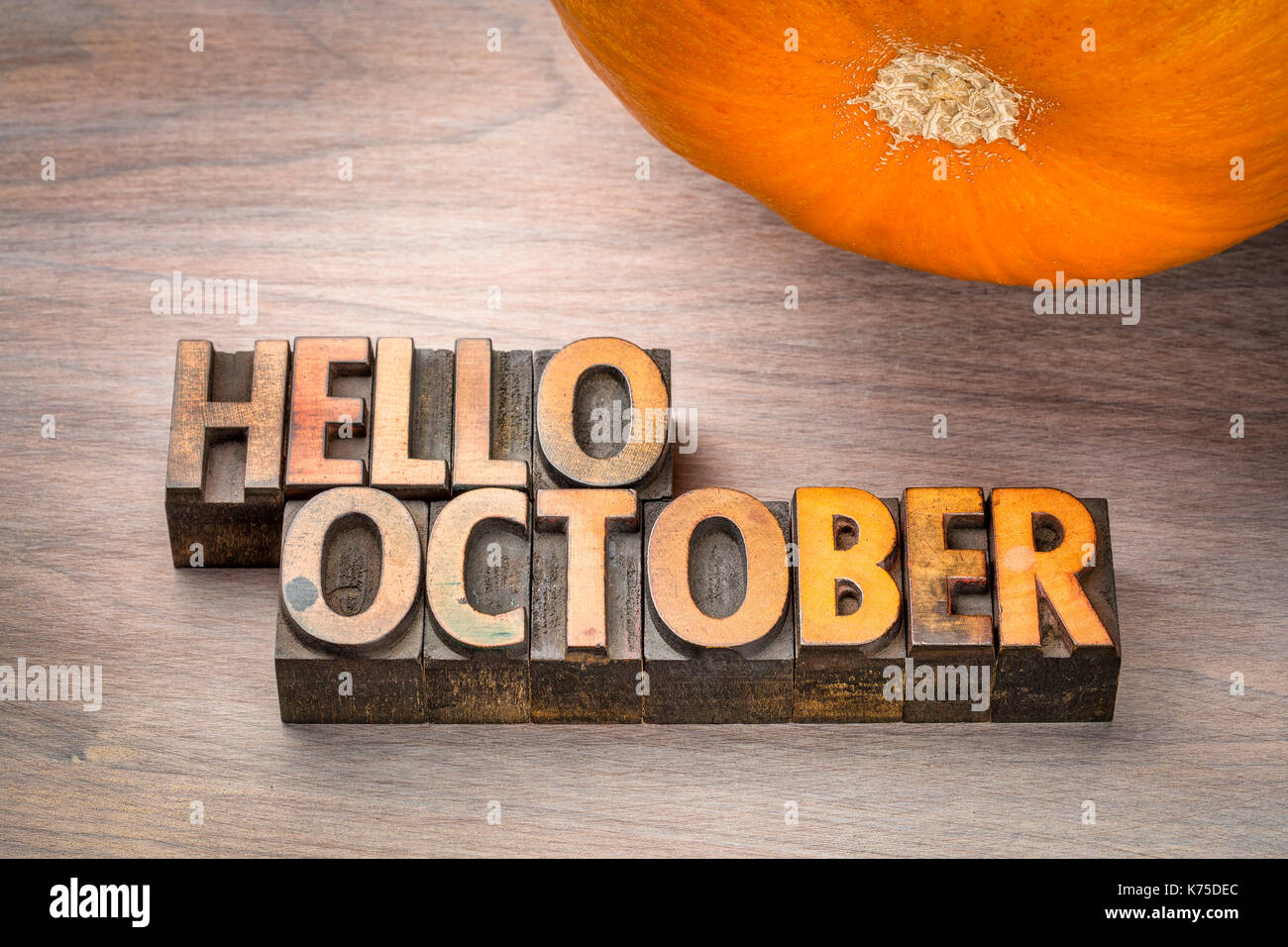 Hallo Oktober Grußkarte - Buchdruck Holz Bausteine gegen gemasertem Holz mit einem Kürbis Stockfoto
