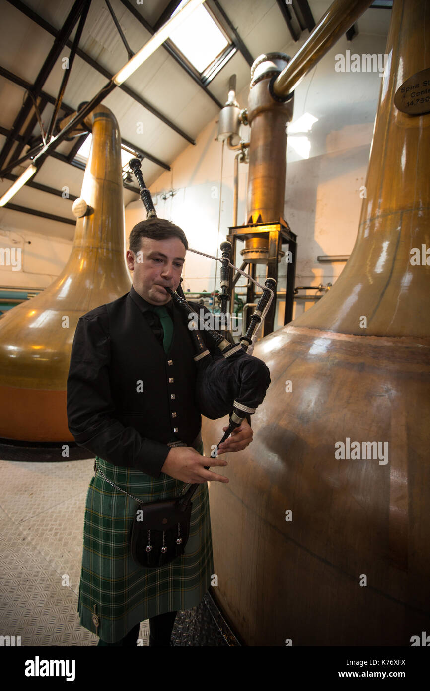 Bowmore Whisky Distillery mit Dudelsackspieler, Bowmore, in Schottland, am 15. September 2017. Stockfoto
