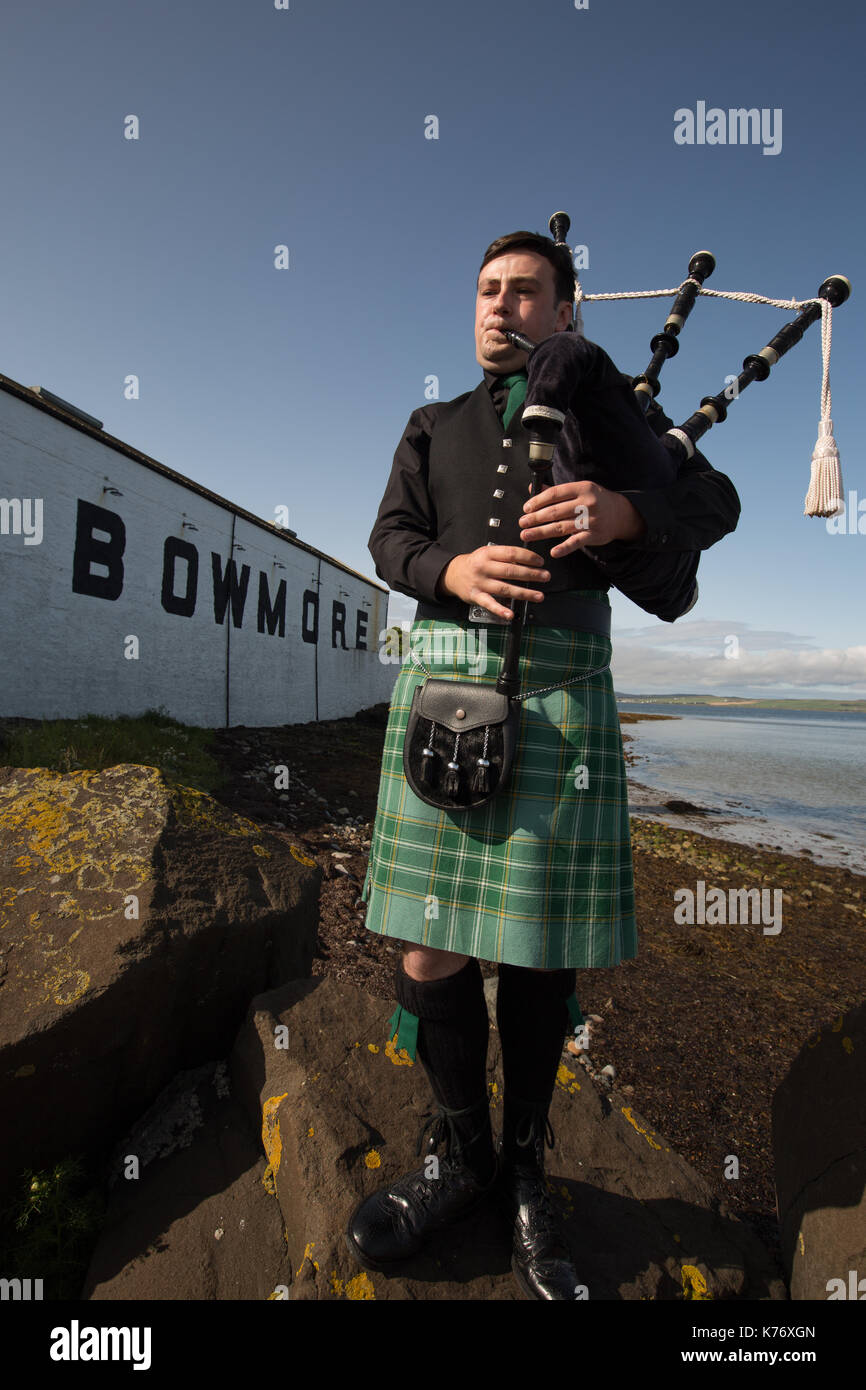Bowmore Whisky Distillery mit Dudelsackspieler, Bowmore, in Schottland, am 15. September 2017. Stockfoto