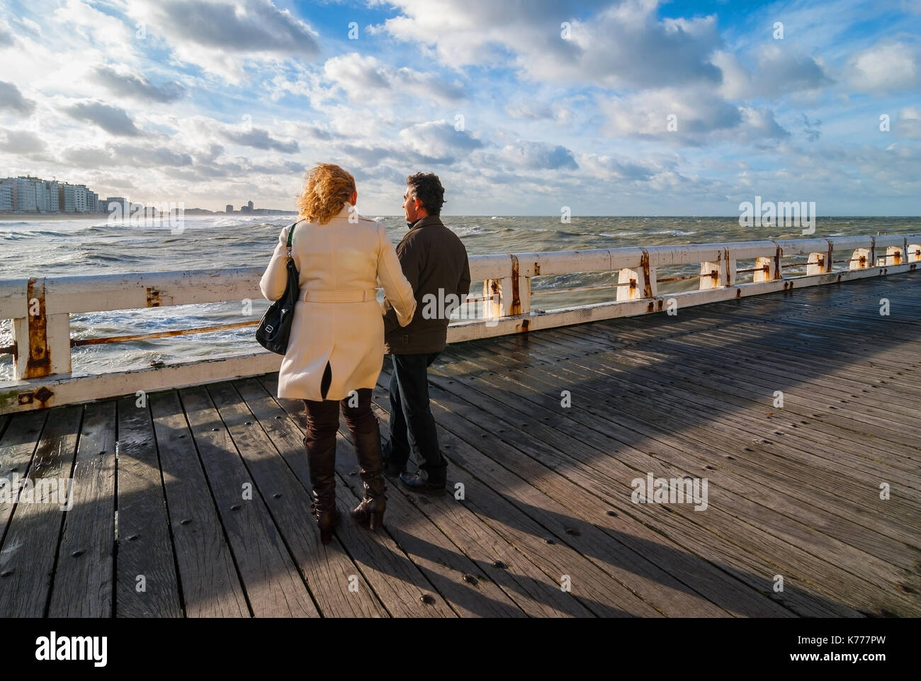 Ein Paar genießt die Aussicht auf die Nordsee und Ostende Skyline von der hölzernen Pier, Belgien gesehen, Westeuropa. Stockfoto