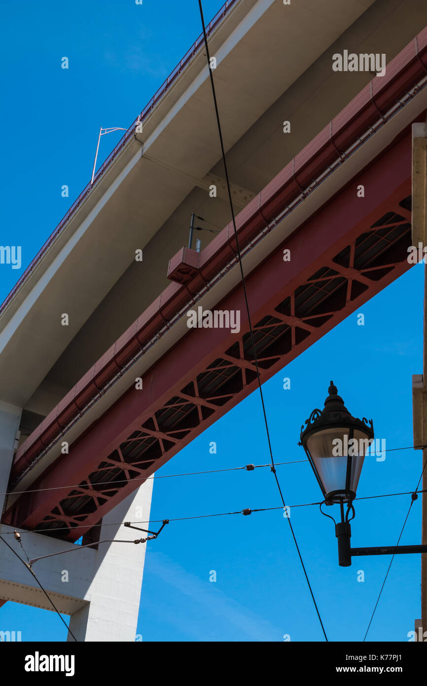 Fragment des 25. April Brücke in der portugiesischen Hauptstadt Lissabon, zusammen mit einem alten Stil street lamp-Laterne. Strahlend blauen Himmel im Hintergrund Stockfoto