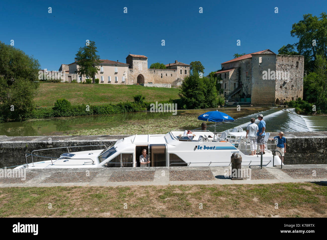 Kanalboot auf einer Schleuse in der Stadt Vianne am Petite Baïse in der Dordogne-Region im Südwesten Frankreichs. Stockfoto