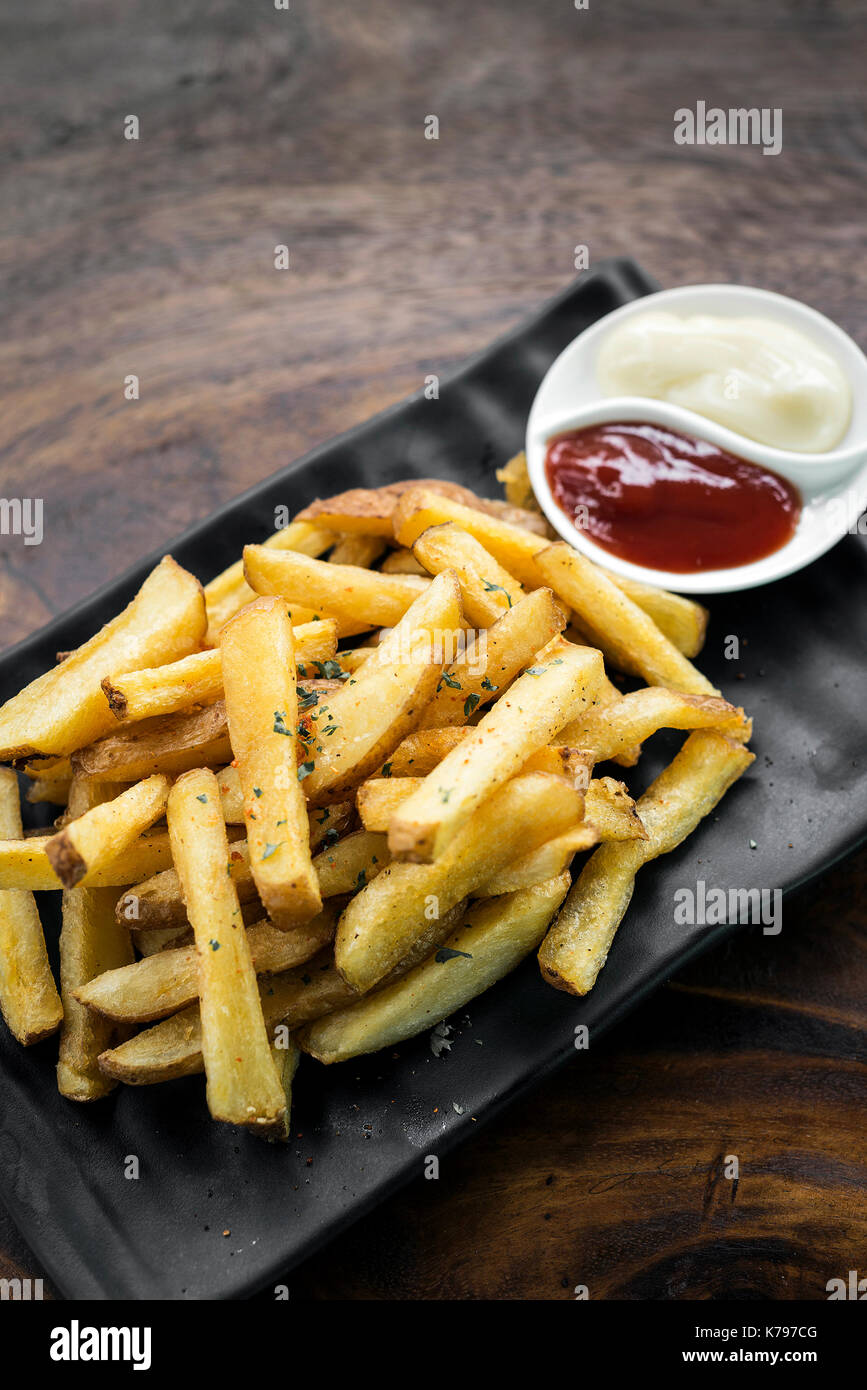 Pommes Chips Snack mit diping Soßen auf hölzernen Tisch Stockfoto