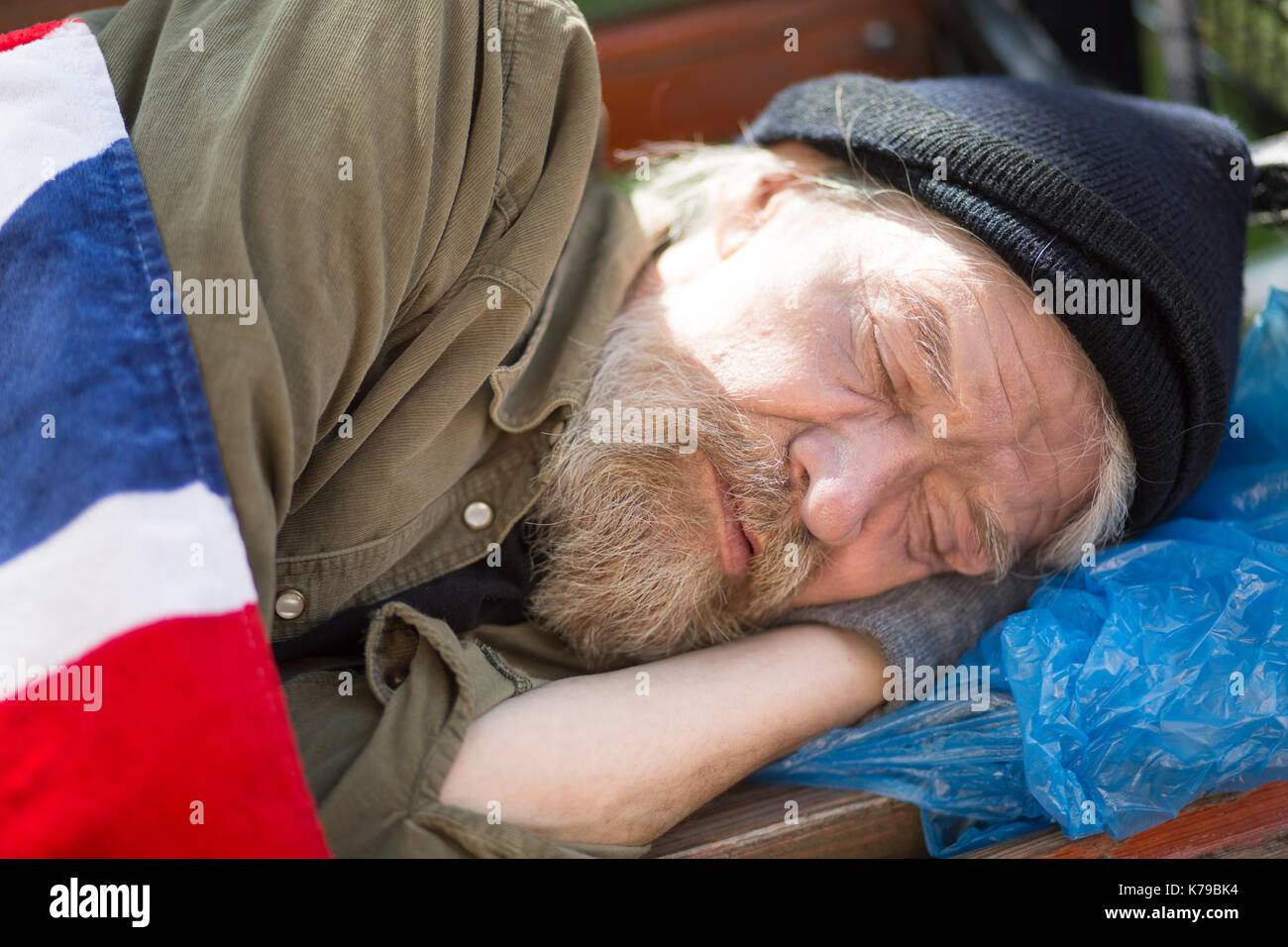 Close up Portrait von Obdachlosen schlafen auf der Werkbank im City Park. Stockfoto