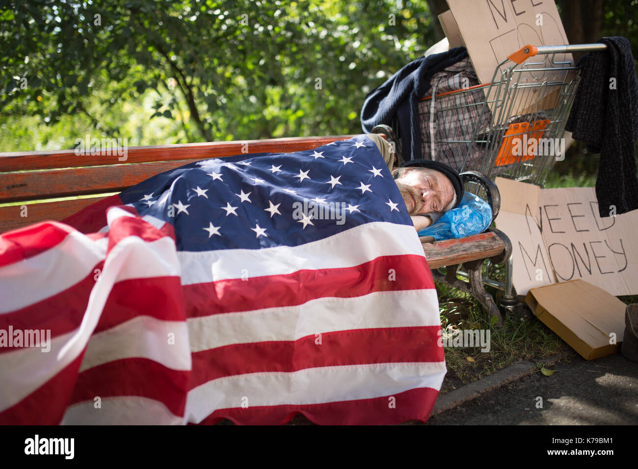 Obdachloser mit USA-Flagge als eine Decke. Stockfoto