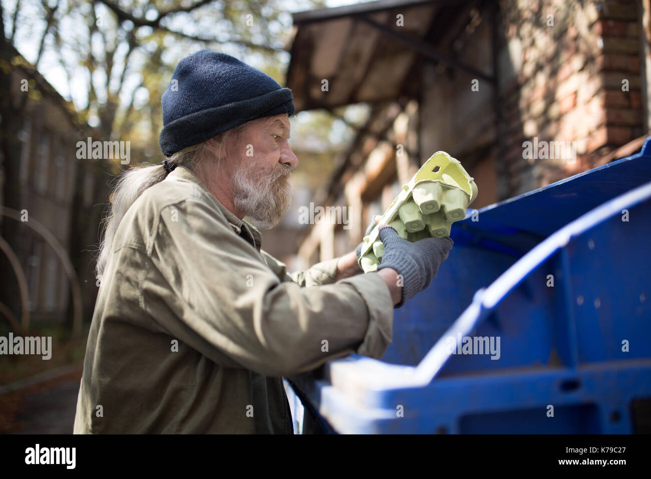 Homeles Mann suche Essen in Thrash können. Stockfoto