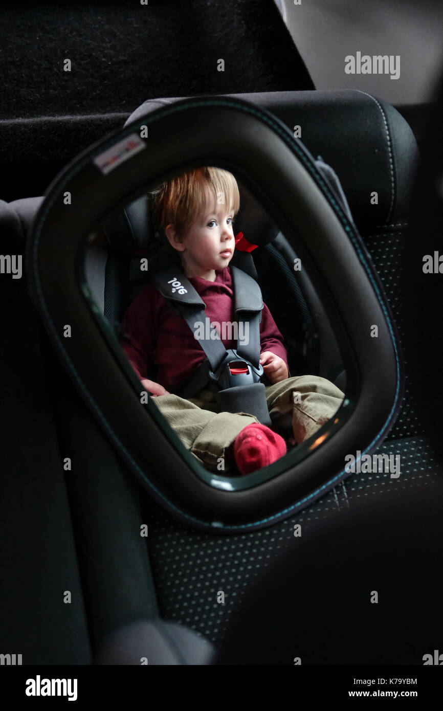 Kind im Kindersitz gesehen durch den hinteren Sitz Spiegel auf der  Rückseite des Autos Stockfotografie - Alamy