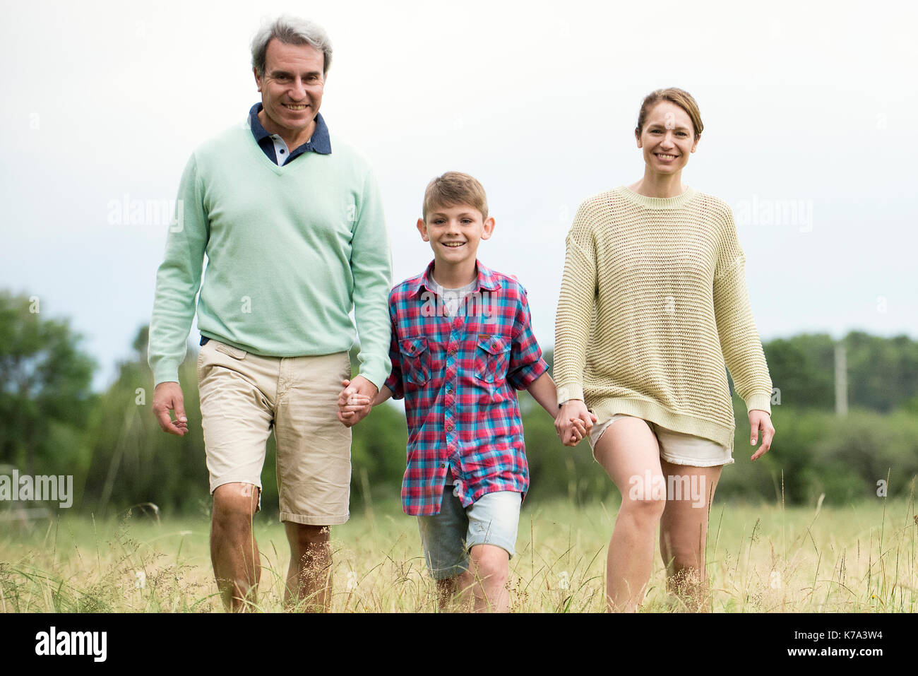 Familie zusammen zu Fuß durch hohes Gras Stockfoto