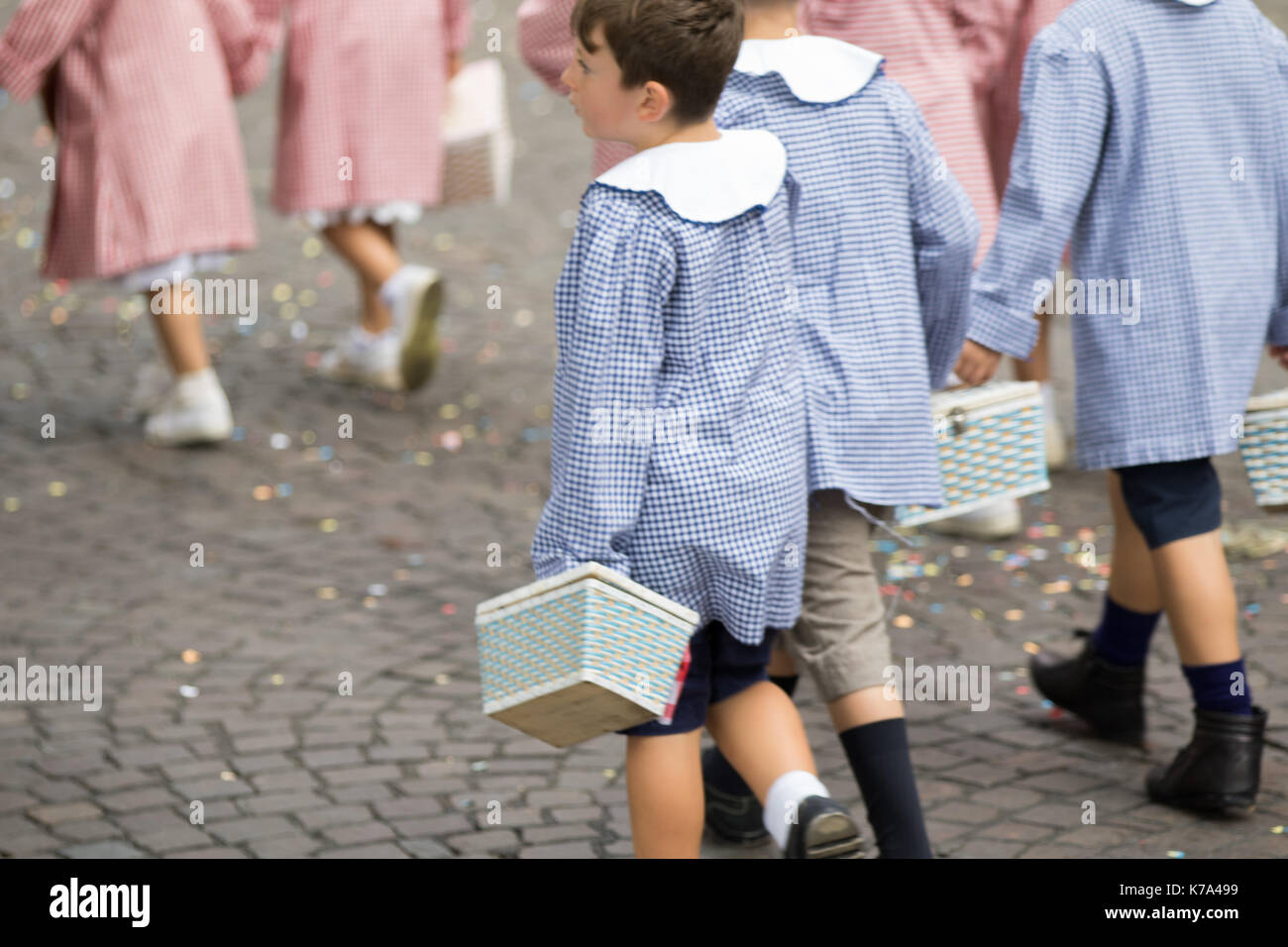 Asti, Italien - 10 September 2017: Kinder mit weißen und blauen Schule square Schürze neigen dazu, mit dem Korb mit Snacks zu Hand Stockfoto