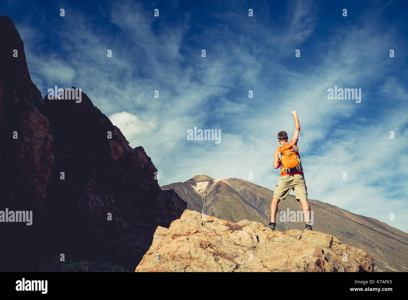Mann mit ausgestreckten Armen feiern schöne inspirierende Aussicht in die Berge. Männliche Wanderer oder Bergsteiger mit Händen genießen Sie inspirierende Landschaft auf Roc Stockfoto
