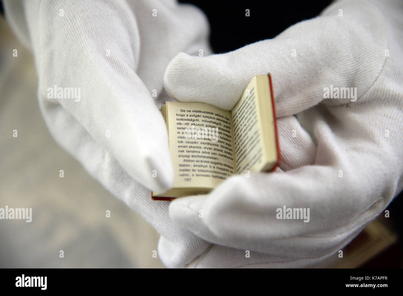 Trier, Deutschland. 15 Sep, 2017. Ein Mitarbeiter des Staatlichen Museums Holding die kleinste Version des "Kommunistischen Manifest" (Budapest, Ungarn, 1971) in Trier, Deutschland, 15. September 2017. 247 internationale Kredite des "Kommunistischen Manifest" von Karl Marx wurden dem Museum geliefert. Eine Ausstellung ist auf Anzeige anlässlich der 200. Geburtstag von Karl Marx in seinem Geburtsort vom 5. Mai bis 21. Oktober 2018. Foto: Harald Tittel/dpa/Alamy leben Nachrichten Stockfoto