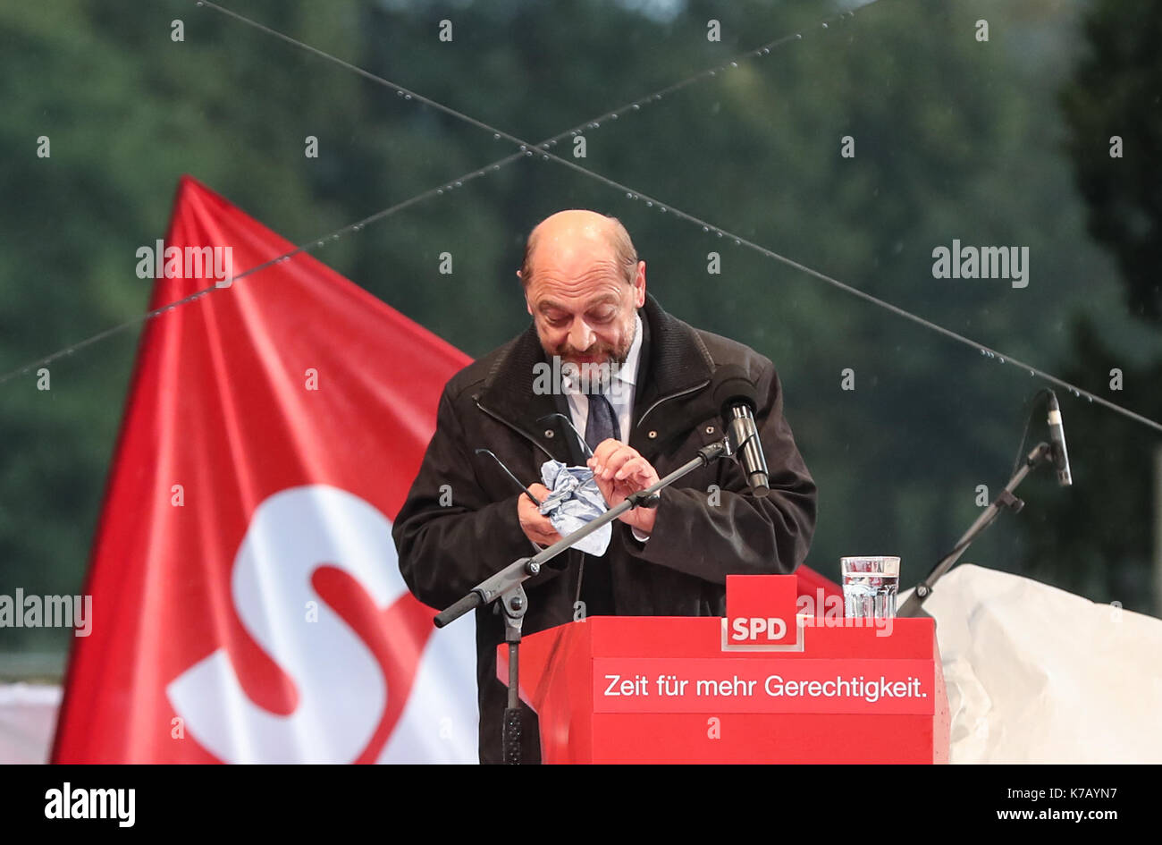 Schwerin, Deutschland. 15 Sep, 2017. Deutschen Sozialdemokraten (SPD) Martin Schulz Wischtücher Regenwasser auf seine Brille während einer Wahlkampagne Rally für den Bundesländern Wahlen, bei denen fällt auf Sept. 24, in Schwerin, Norddeutschland, on Sept. 15, 2017. Credit: Shan Yuqi/Xinhua/Alamy leben Nachrichten Stockfoto