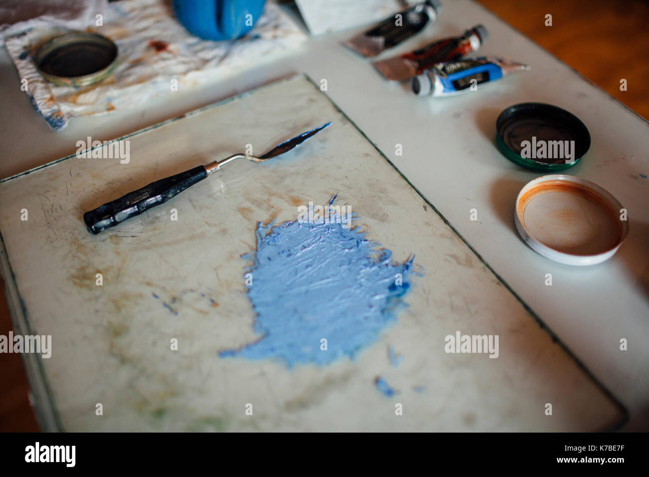 Close-up Blau aquarell Malen durch Abstreifer auf Fach am Tisch in der Werkstatt Stockfoto