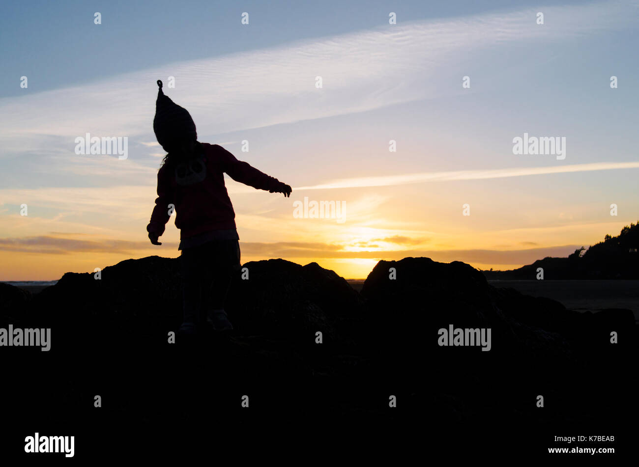 Silhouette stehendes Mädchen auf dem Land gegen Himmel bei Sonnenuntergang Stockfoto