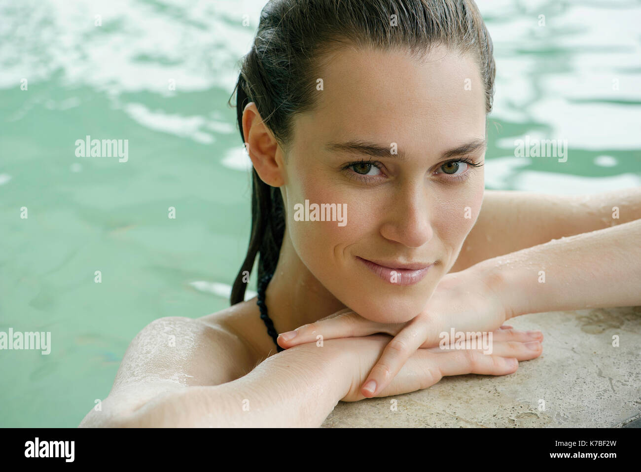 Frau in Swimming pool an Kante Kopf auf die Arme Stockfoto