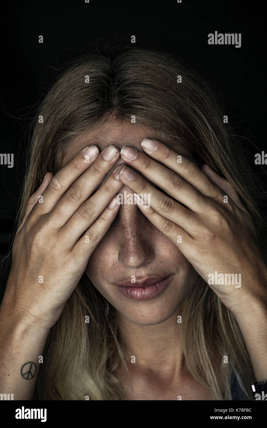 Frau, die Augen mit den Händen Stockfoto