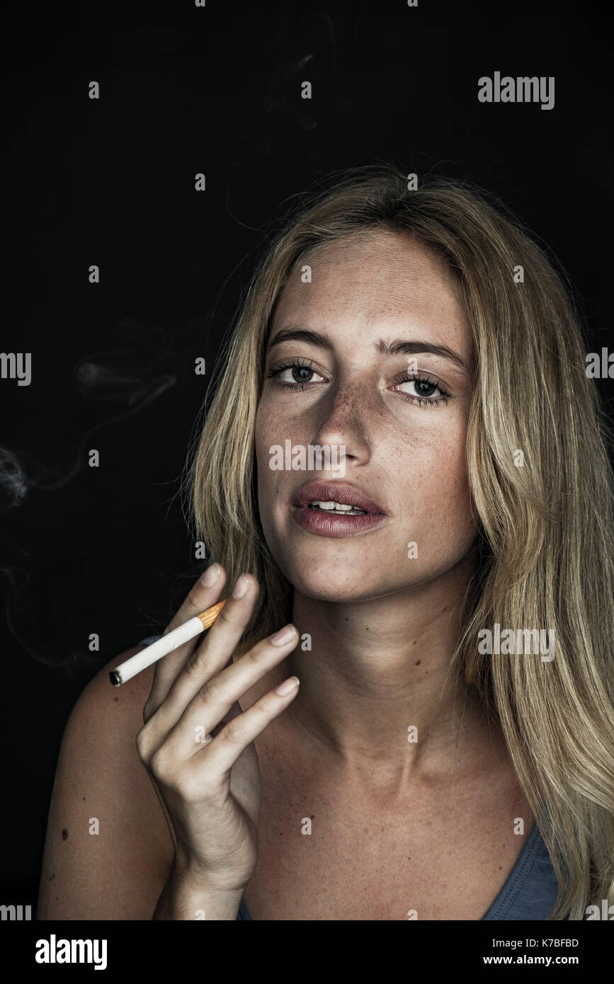 Junge Frau rauchen Zigarette, Porträt Stockfoto