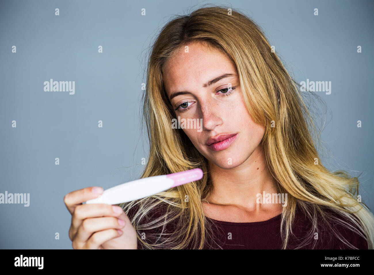 Junge Frau von der Schwangerschaft Test mit enttäuscht Ausdruck suchen Stockfoto