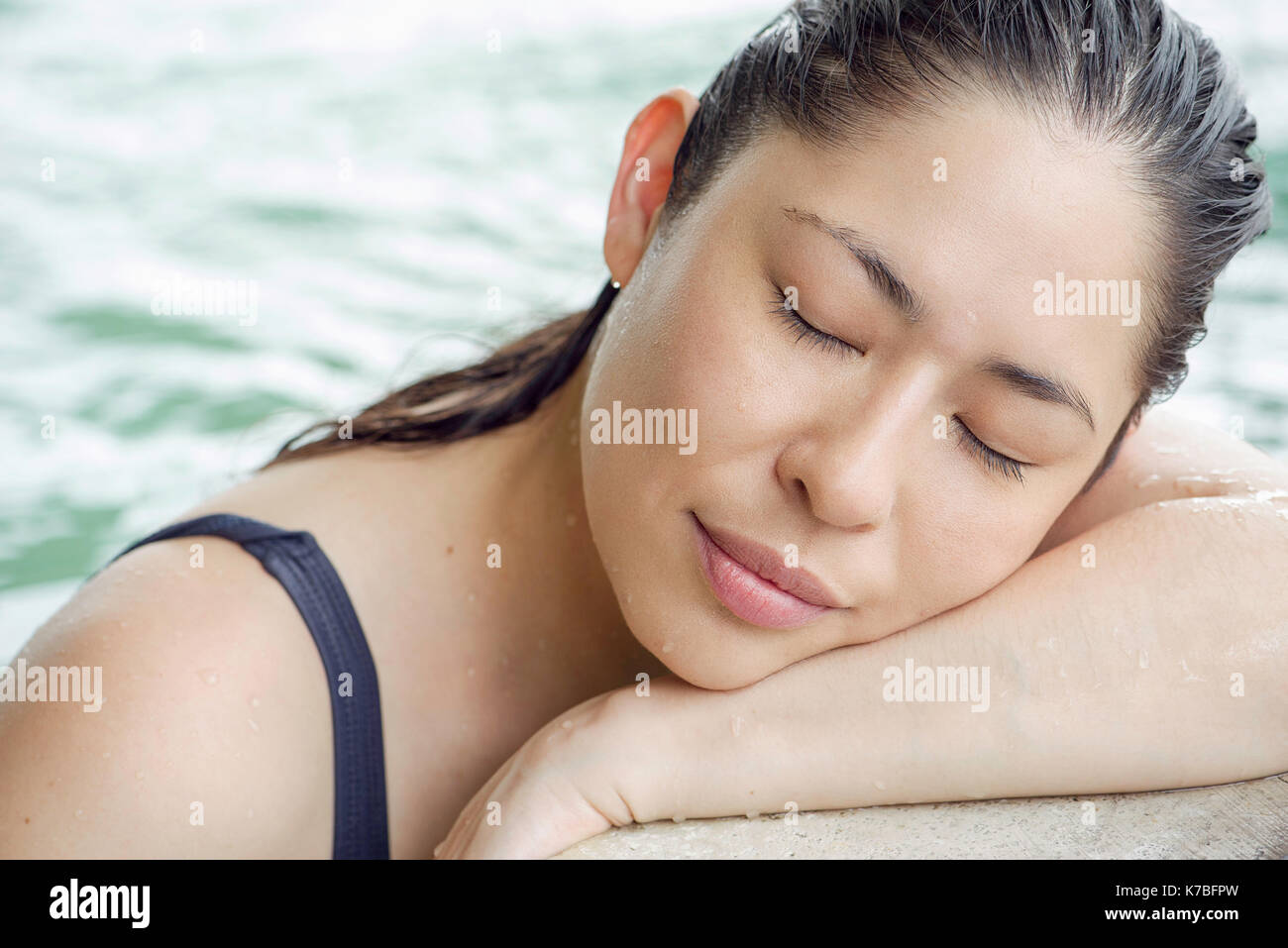 Frau an der Seite des Pools ruhender Kopf auf die Arme Stockfoto