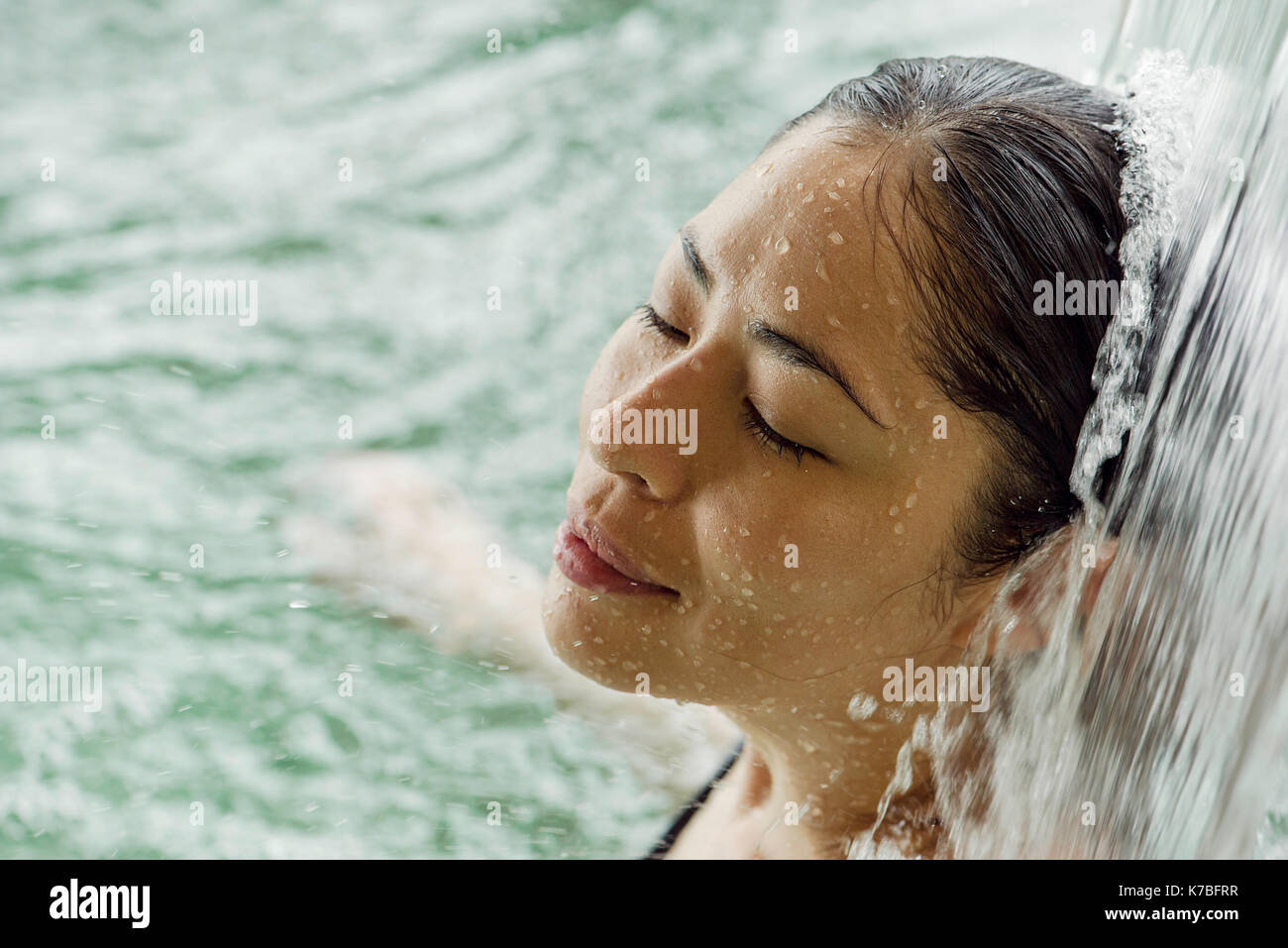 Frau unter fließendem Wasser Stockfoto