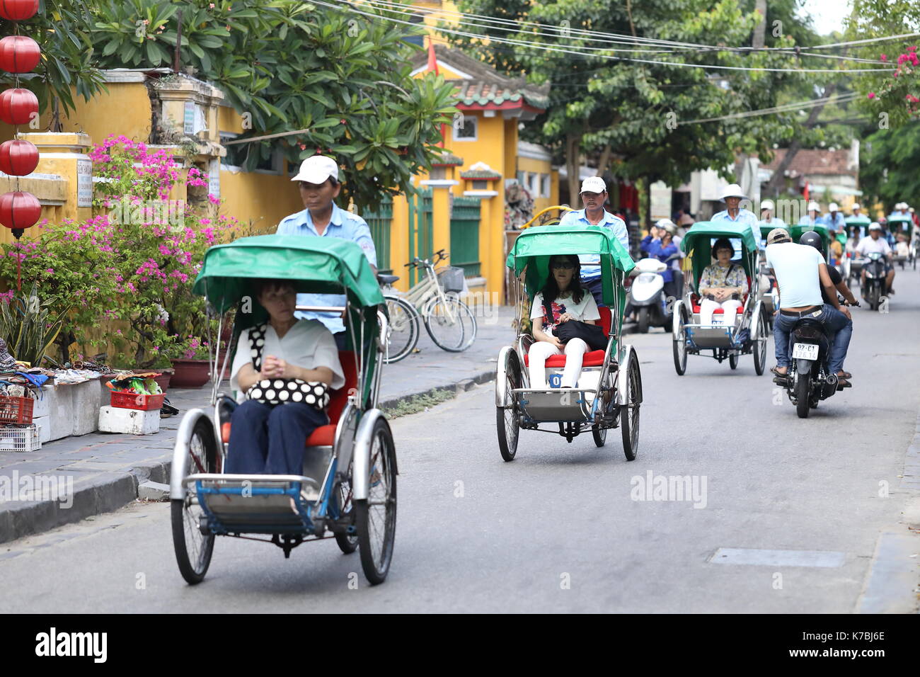Touristen Reiten in Rikschas um die Altstadt in Hoi An, Vietnam Stockfoto