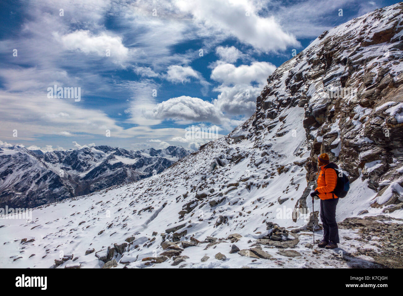 Frau Berg Walker auf Schnee tragen orange Daunendecke Jacke Stockfoto