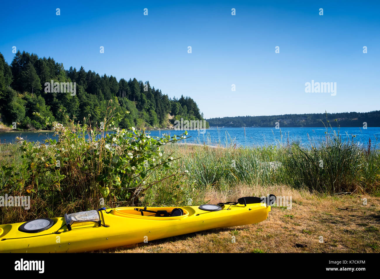 Gelbe Kajak auf der Wiese neben dem Wasser auf Vashon Island, Washington. von Seattle. Stockfoto