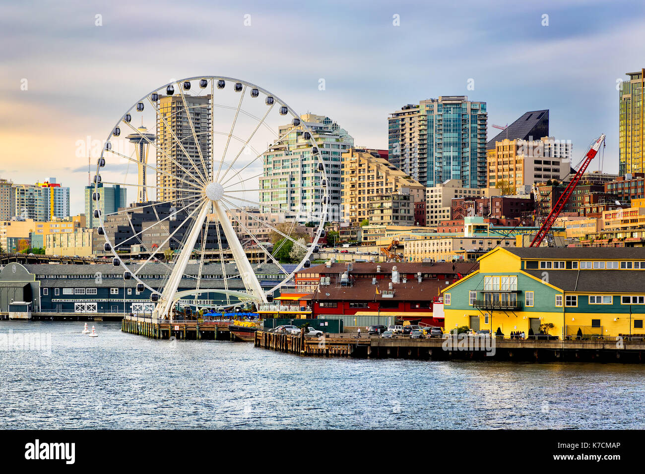 Seattle Riesenrad und Waterfront. Space Needle im Hintergrund. gold Sonnenuntergang Licht. vom Wasser gesehen. Stockfoto