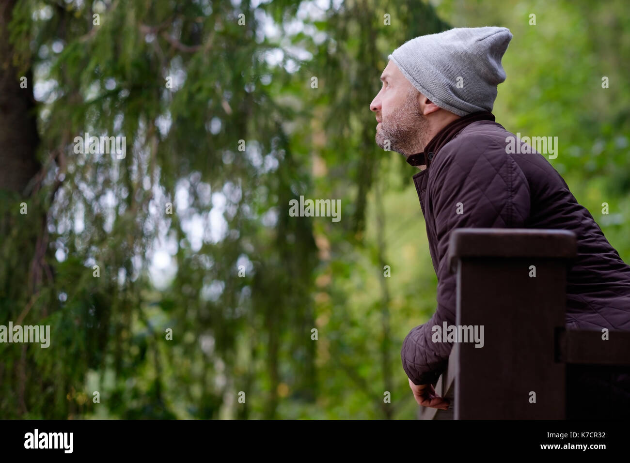 Stattliche reifer Mann lächelnd in warme Mütze und Jacke zur Seite suchen Stockfoto