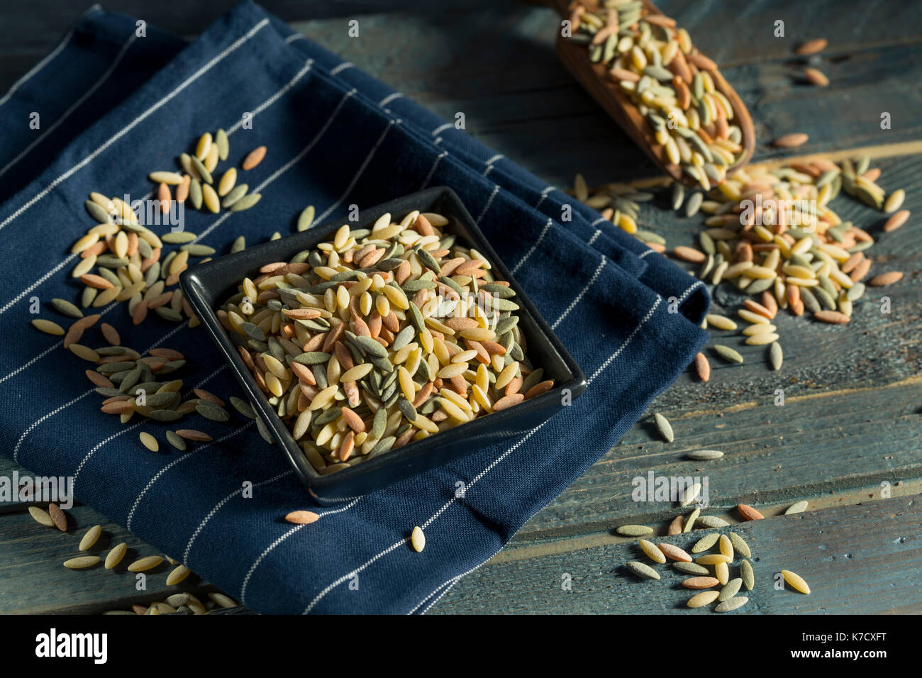 Trockene organische Tricolor Orzo Pasta in eine Schüssel geben. Stockfoto