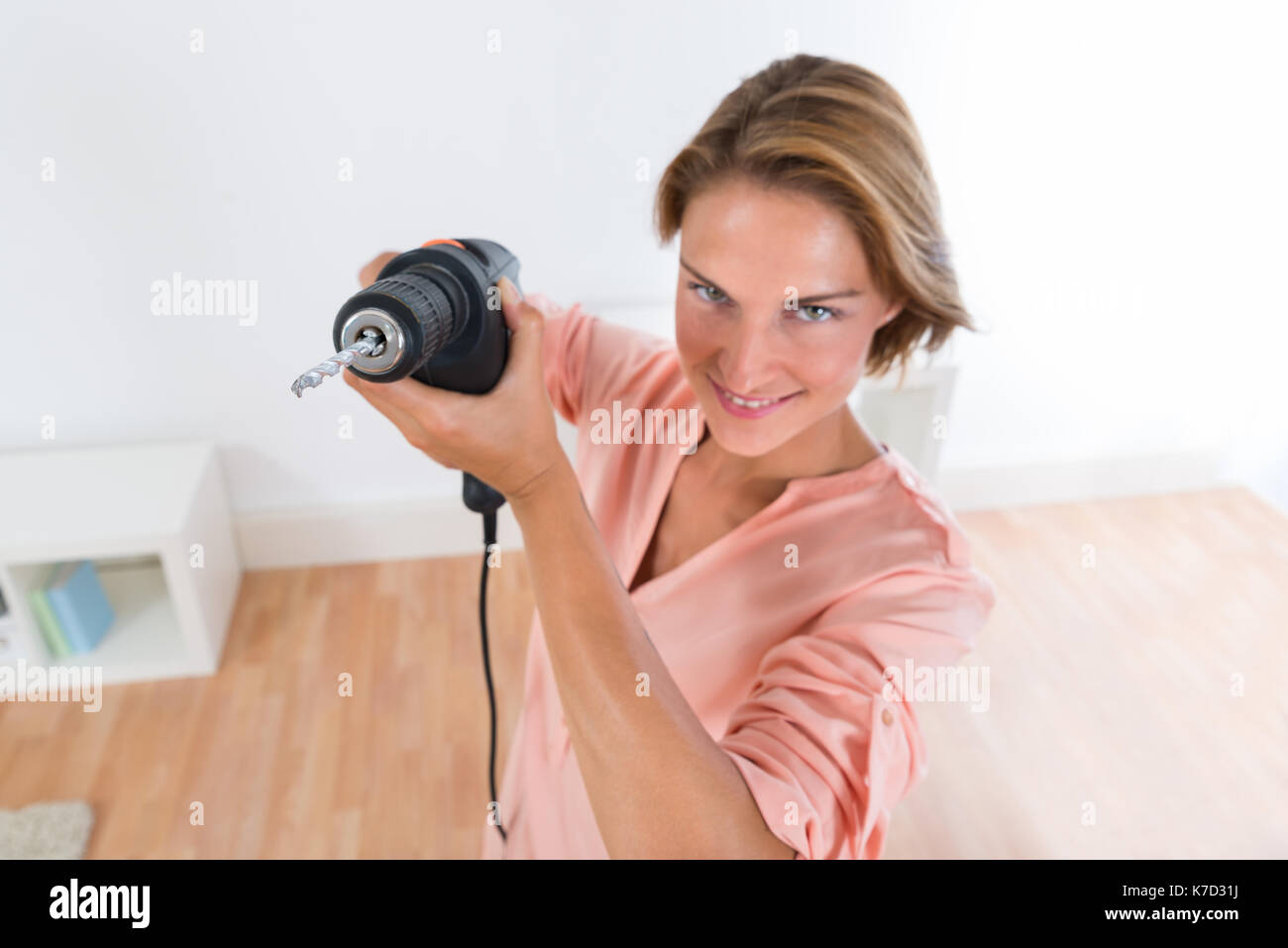 Porträt der Glückliche junge Frau mit Bohrmaschine Stockfoto