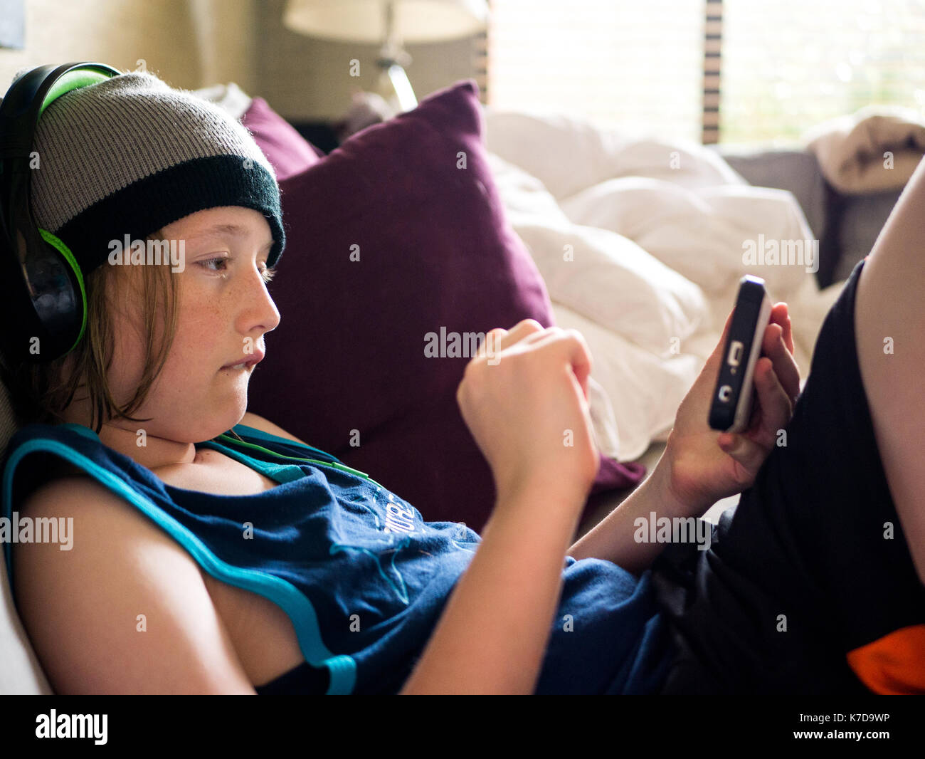 Junge mit Smart Phone beim Hören von Musik zu Hause. Stockfoto