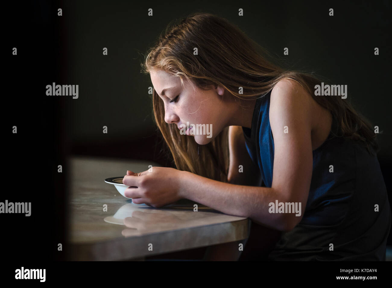 Seitenansicht des Mädchens, das Frühstück am Tisch Stockfoto