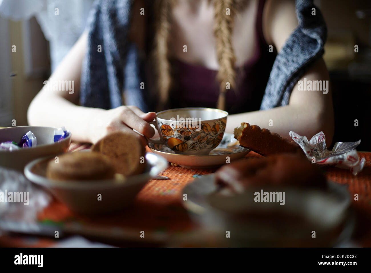 Mittelteil der Frau mit Tasse Tee beim Sitzen am Esstisch Stockfoto