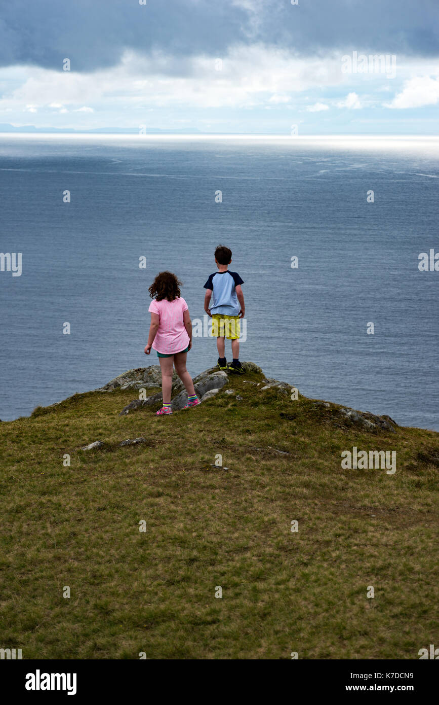 Mädchen und Jungen, die über Slieve League Cliffs, County Donegal, Irland Stockfoto
