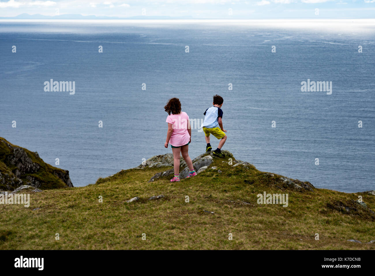Mädchen und Jungen, die über Slieve League Cliffs, County Donegal, Irland Stockfoto