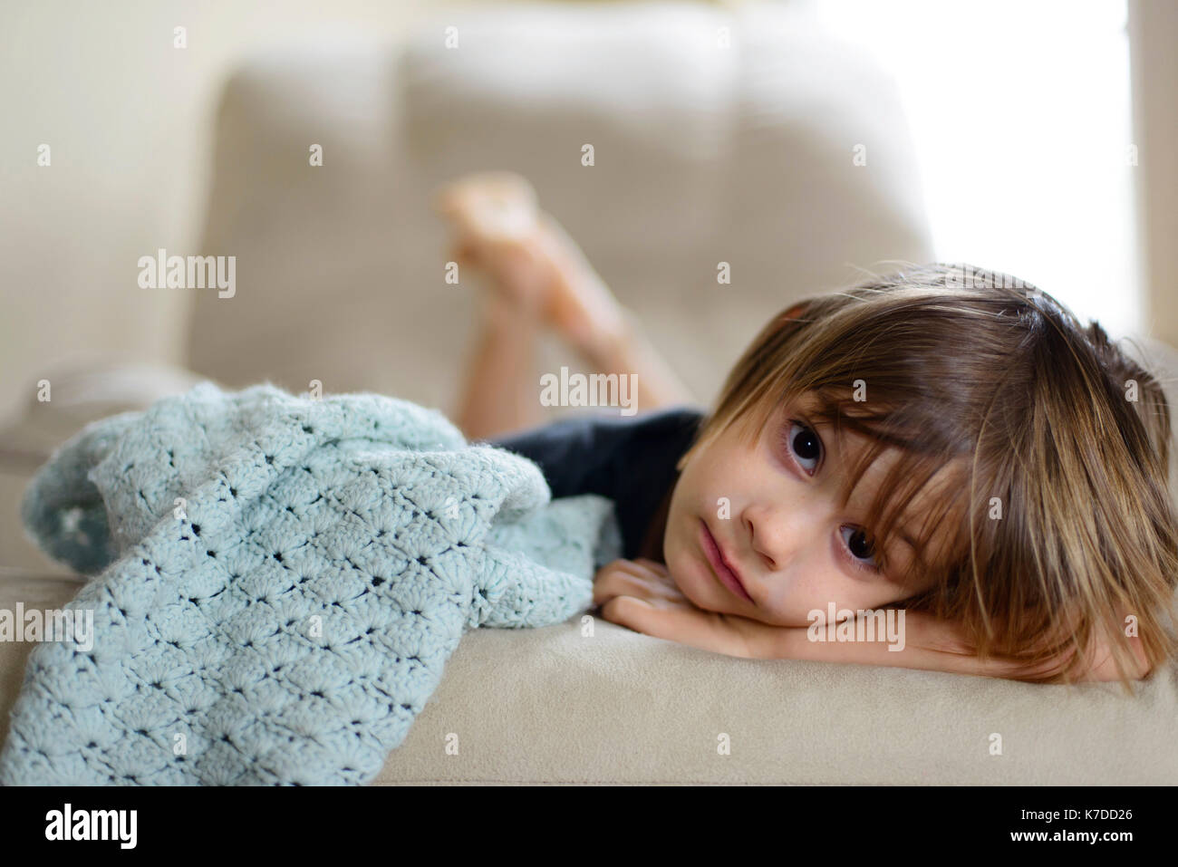 Portrait von Mädchen liegt auf dem Sofa zu Hause Stockfoto