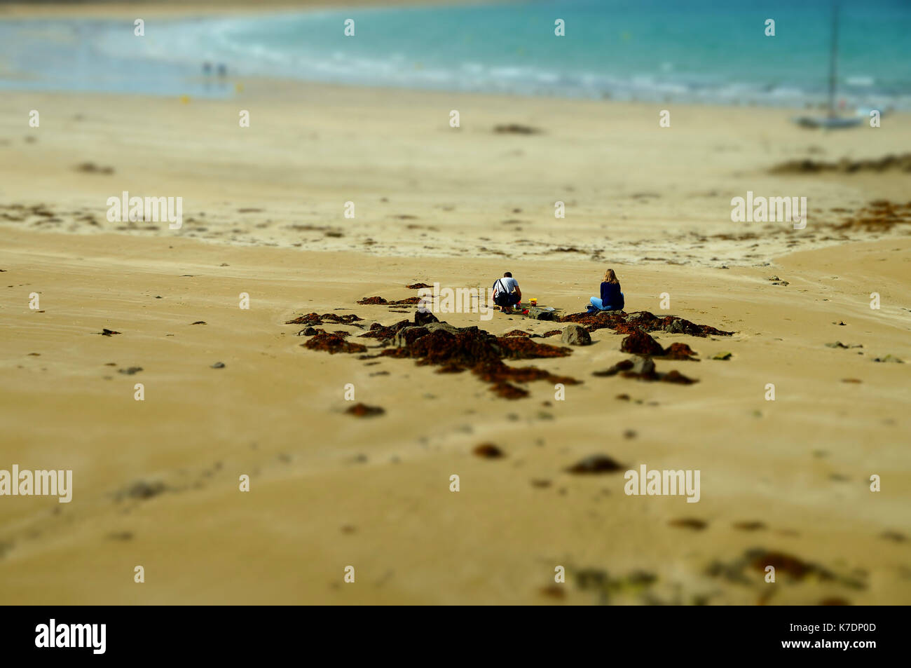 Paar am Strand, bhudda als winzige Modelle Stockfoto